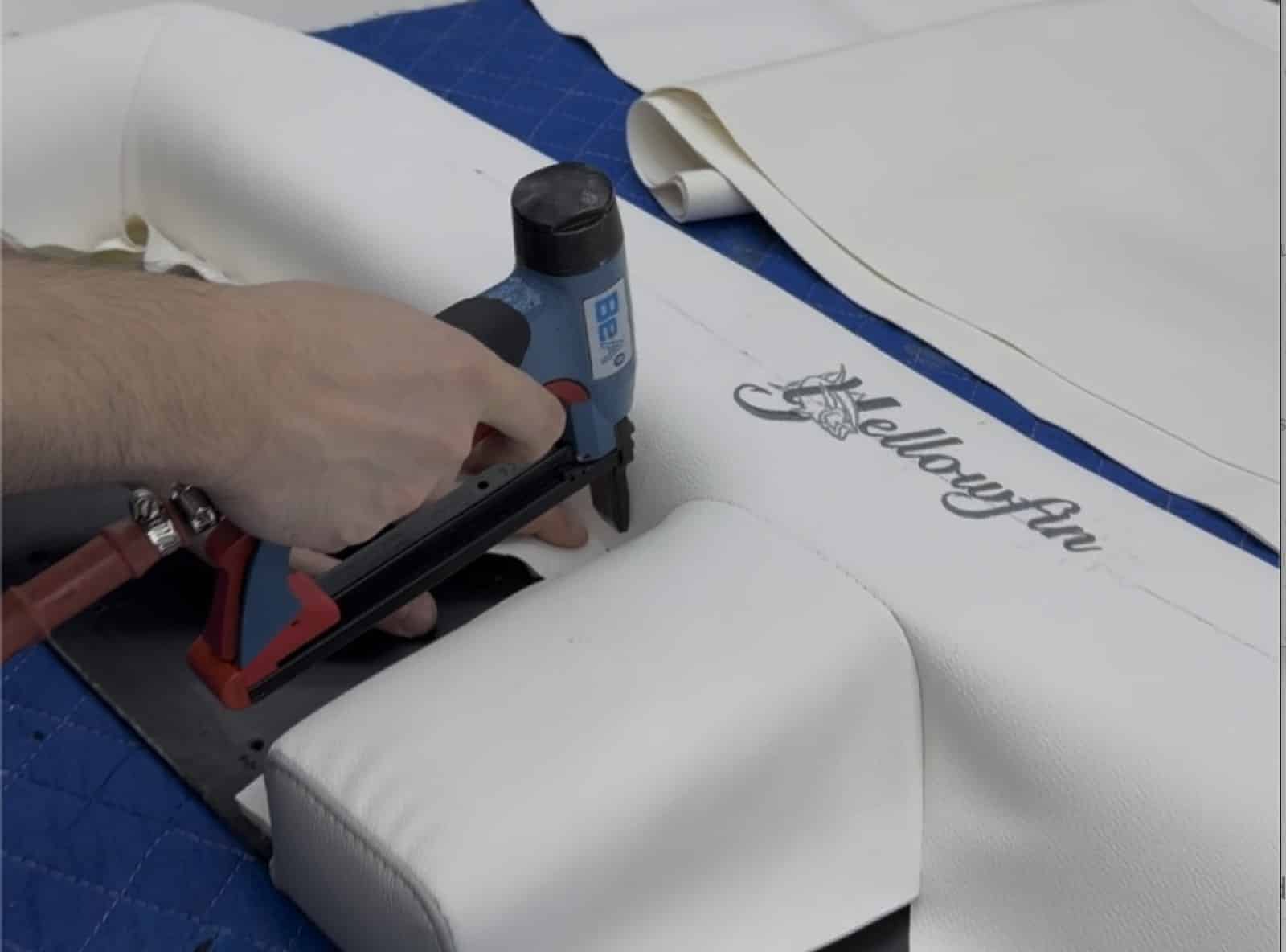 Securing white upholstery with custom gray embroidery during workshop assembly